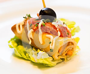 Pincho roll with olives on salad leaf