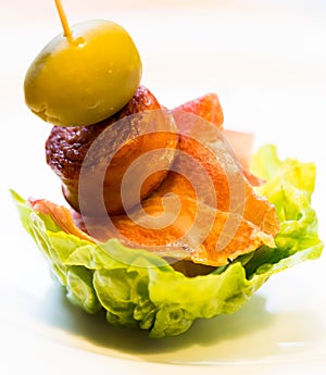 Pinchos with olives on salad leaf