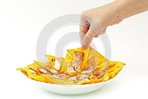 Pincking tortila chips covered with cheese (Nachos) from white d