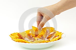 Pincking tortila chips covered with cheese (Nachos) from white d