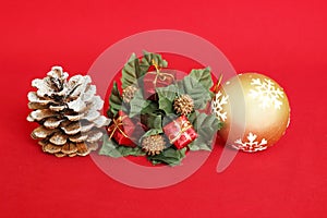 pine apple with snow, red gifts and a golden ball on a red background for holiday decoration