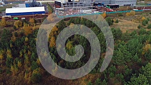 Pine and birch forest near open industrial complex site