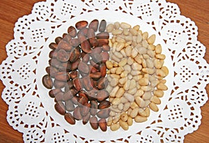 Pine brown and yellow nuts are laid out on a white napkin. Brown, beige, white, contrast.