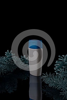 pine christmas shampoo. White shampoo bottle with spruce and cones on a black background