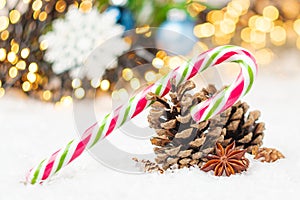 Pine cones, candy stick, anis star on the snow. Christmas composition with copy space.