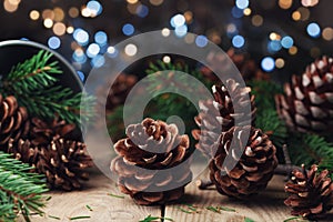 Pine cones and fir tree branch on rustic wooden table. Christmas greeting card.