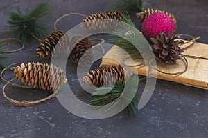 Pine cones, red decorations on a dark background. Christmas, winter holidays, new year concept. Flat lay, copy space, close up