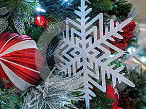 Pine cones, snowflakes, peppermints, and other ornaments decorating a Christmas tree for the holiday