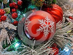 Pine cones, snowflakes, peppermints, and other ornaments decorating a Christmas tree for the holiday