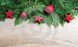 Pine leaf with red star and christmas ball decoration on woode