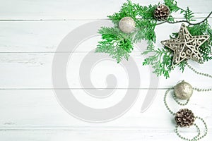Pine leaf with silver star and christmas ball decoration on white wooden board with copy space , happy new year and chistmas festi photo
