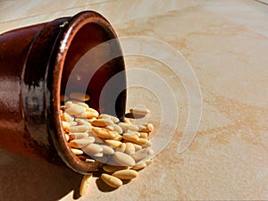 Pine nuts falling from a small clay container