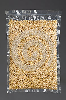 Pine nuts packed in vacuum bag, gray background