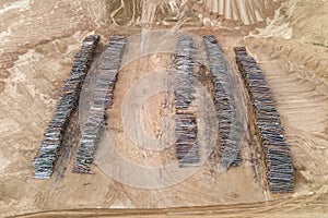 Pine tree logs after felling site. Arial view of stacks of cut wood. Environmetal and illegal deforestation. Logging industry.