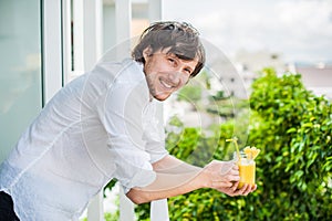 Pineapple cocktail with a slice of in the hands man on the terrace. Tropical concept