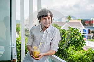 Pineapple cocktail with a slice of in the hands man on the terrace. Tropical concept