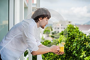 Pineapple cocktail with a slice of in the hands man on the terrace. Tropical concept