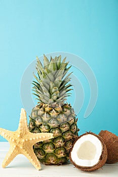 Pineapple with coconut on blue background. Tropical fruit. Vertical photo