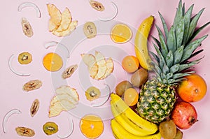 Pineapple. coconut, orange, bananas and dry fruit chps on pink background
