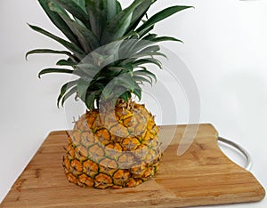 Pineapple cut in half on a chopping board