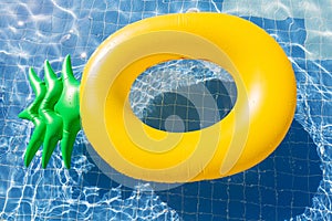 Pineapple float ring on the blue swimming pool