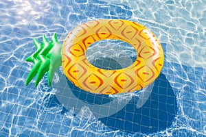 Pineapple float ring on the blue swimming pool