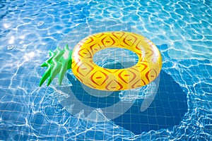Pineapple float ring on the blue swimming pool