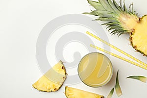 Pineapple, glass of juice, straws and slices on white background