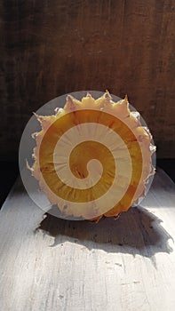 Pineapple and its shadow on the cement floor.