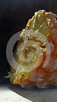 Pineapple and its shadow on the cement floor.