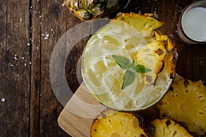 Pineapple juice and piece of fruits ready to eat on the wood tab