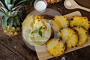 Pineapple juice and piece of fruits ready to eat on the wood tab