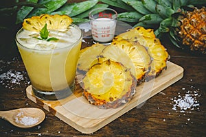 Pineapple juice and pineapple slices cut into pieces on a wooden table. Healthy wood fiber helps to reduce food. Pineapple juice
