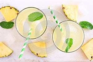 Pineapple juice, top view on a white marble background