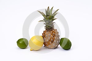 Pineapple with lemon and lime on a white background. Green lime, pineapple close-up and yellow lemon on an isolated white backgrou