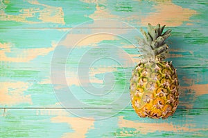 Pineapple over wooden background. Tropical summer vacation concept.