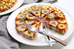 pineapple pizza slices arranged radially on a white plate with a silver fork