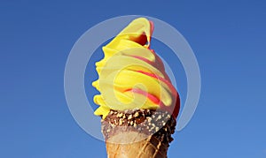 Pineapple and Raspberry Flavored Soft Serve Ice Cream Cone on Vivid Blue Sky