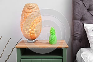 Pineapple shaped candle and lamp on bedside table