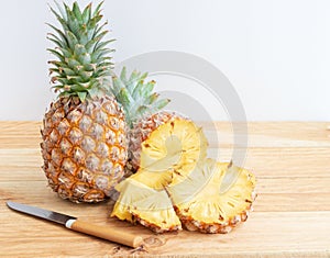 Pineapple slice with knife on wooden table