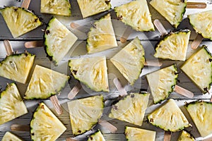 Pineapple slice popsicles on a white rustic wood background, Pop