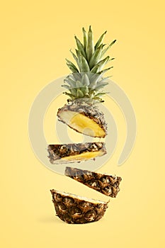 Pineapple sliced, levitates in the air. Concept of summer mood on a yellow background