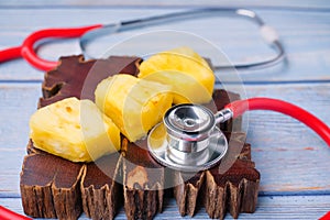Pineapple sliced and stethoscope on wooden background