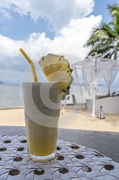 Pineapple smoothie on table with sea view