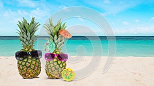 Pineapple with sunglasses on the beach. Tropical vacation and honeymoon concept.