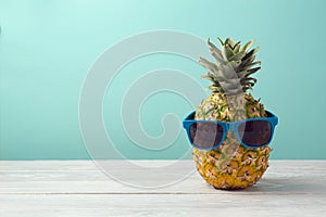 Ananas sluneční brýle na dřevěný stůl přes máta. tropický dovolená a pláž oslava 