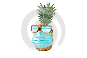 Pineapple wearing surgery protection mask and sunglasses with reflected torpical beach