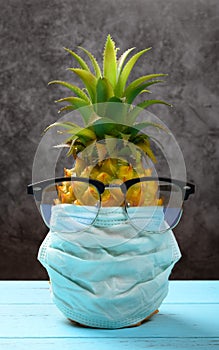 pineapple wears medical mask and an eye protector concept of protecting oneself against the virus