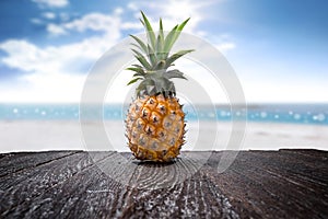 Pineapple on wooden desk and beach side background