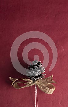 Pinecones Christmas ornament on red wrapping paper
